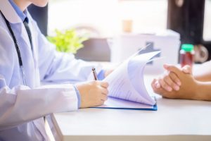 cuide-al-paciente-asesor-hombre-mientras-que-llena-formulario-solicitud-escritorio-hospital_1150-12966